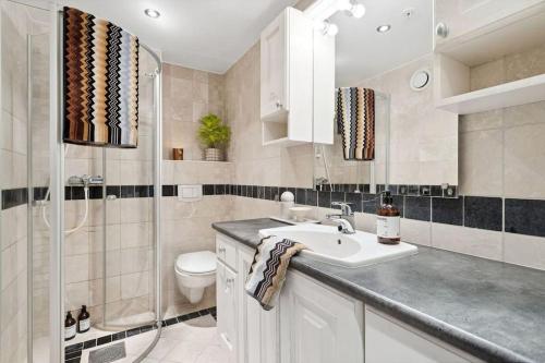 a bathroom with a sink and a toilet at Bryggeleilighet med balkong i Trondheim Sentrum in Trondheim