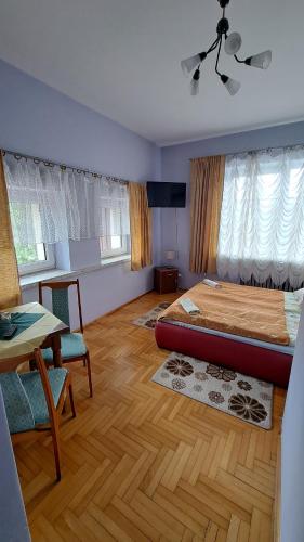 1 dormitorio con 1 cama, mesa y sillas en Zajazd-restauracja Zyga en Iwkowa