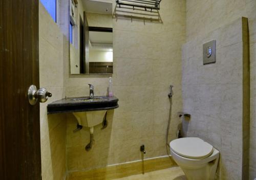 a bathroom with a toilet and a sink at Hotel Lembord Inn - BY - New Cashew Hotel in New Delhi