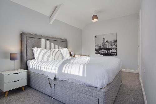 a bedroom with a large bed with white sheets at Ashley Road Apartments in Poole