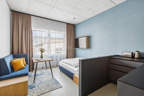 ein Hotelzimmer mit einem Bett, einem Schreibtisch und einem Stuhl in der Unterkunft Nena Apartments München City - NEW OPENING 2024 in München