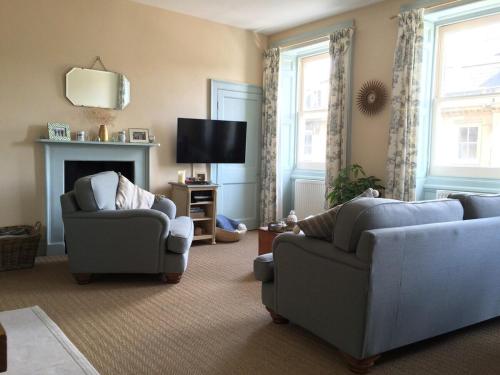 uma sala de estar com duas cadeiras e uma televisão em ※ Beautiful Georgian Apartment - Central Bath ※ em Bath