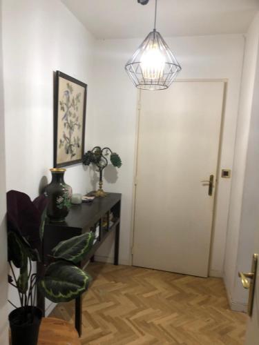 une chambre avec une porte, une table et une lampe dans l'établissement BEL ET SPACIEUX APPARTEMENT AVEC TERRASSES ET JARDINS EN RDC / COUR PROCHE RER B ET TRAM BANLIEUE PARIS SUD, à Châtenay-Malabry
