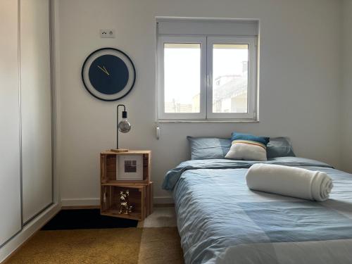 um quarto com uma cama e um relógio na parede em Verderena Guest Room no Barreiro