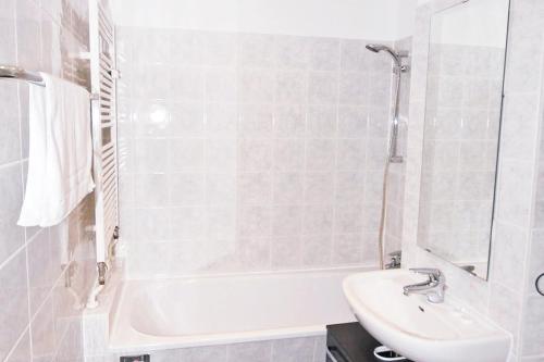 a white bathroom with a sink and a bath tub at Wonderful apartment in the heart of Berlin in Berlin