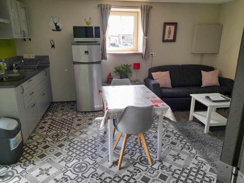 kuchnia i salon ze stołem i kanapą w obiekcie Le Cerf volant w mieście Libin