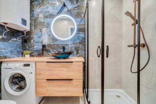 een badkamer met een wasmachine en een douche bij Apartamenty Franciszkańska in Opole