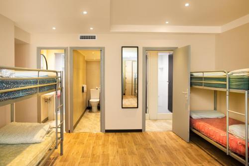a hostel room with bunk beds and a bathroom at Villa Saint Exupery Beach Hostel in Nice