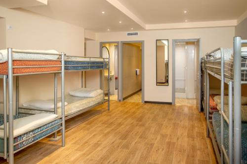 a room with several bunk beds and a hallway at Villa Saint Exupery Beach Hostel in Nice