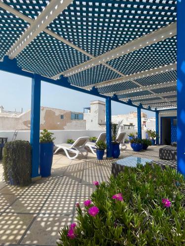 a blue pergola with purple flowers on a patio at Riad Al Madina in Essaouira
