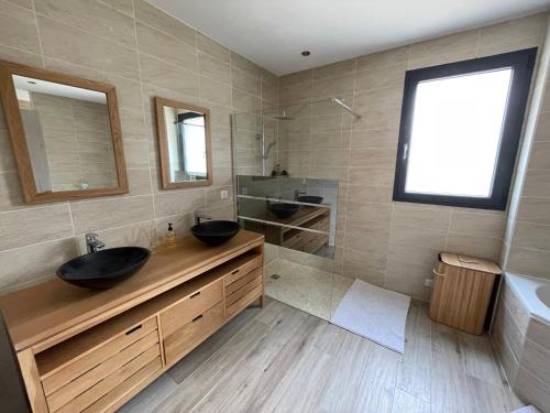 a bathroom with two sinks and two mirrors at Maison vacance caseneuve in Caseneuve