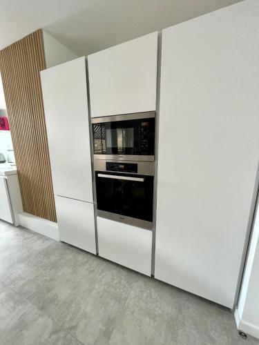 d'une armoire blanche avec un four micro-ondes. dans l'établissement Stylish modern large 2 Bedrooms 5 min close to Paris, à Levallois-Perret