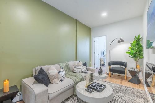 a living room with a couch and a table at Sage Stay by the Train, We Pay Half Your Parking, 2 Queen Beds plus Sleeps 6 in Hoboken