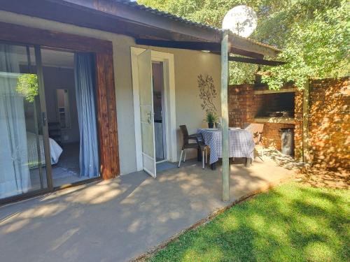 a patio with a table and chairs in a yard at Shangrila-innibos Country Lodge in Hartbeespoort