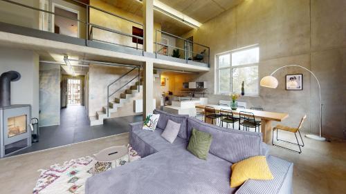 un soggiorno con divano grigio e una sala da pranzo di The Sunset Club - LOFT - 155 m2 Sichtbeton - Zentral a Memmingen