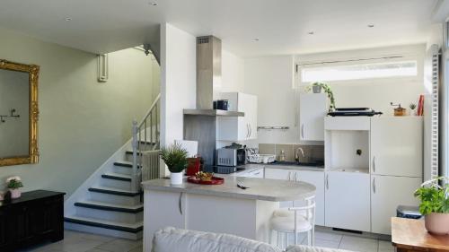 une cuisine avec des placards blancs et un escalier dans l'établissement Maison de vacances calme pour 4-6 personnes, à Saint-Palais-sur-Mer