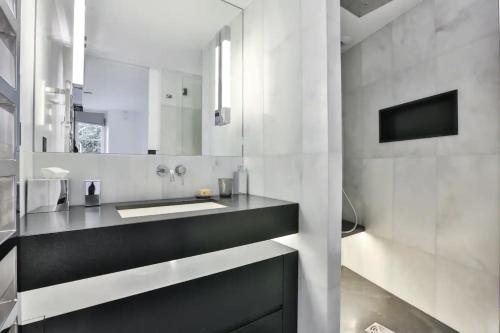 une salle de bain avec un lavabo et un miroir dans l'établissement St-Germain/Louvre - Stylish townhouse of 1600, à Paris