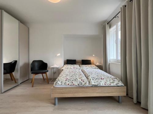 - une chambre avec un lit, une chaise et une fenêtre dans l'établissement SOMMERHAUS JOSEFA, à Mühldorf