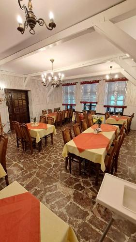 a dining room with tables and chairs and a chandelier at Zajazd-restauracja Zyga in Iwkowa