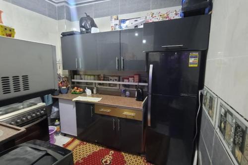 una cucina con frigorifero nero in camera di استديو غرفة نوم و ريسبشن و روف تراس a Il Cairo