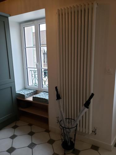 a room with a window and a vase in a room at L'ESTAMPE in Auvers-sur-Oise