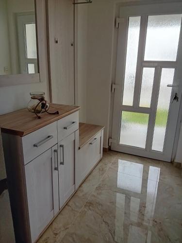 a kitchen with white cabinets and a large window at Tina in Pula