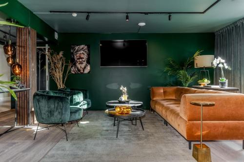 a living room with a brown couch and green walls at xhotel in Ludvika