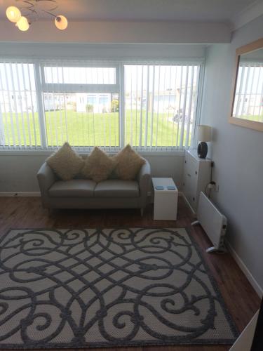 a living room with a couch and a rug at Collier's Corner Chalet California Sands Scratby Great Yarmouth in Scratby