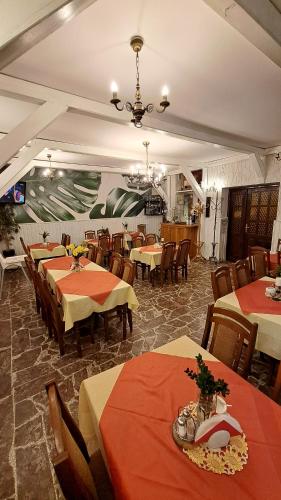 a restaurant with tables and chairs and a chandelier at Zajazd-restauracja Zyga in Iwkowa