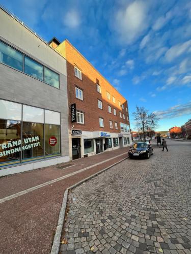 a car parked on a cobblestone street next to a building at xhotel in Ludvika