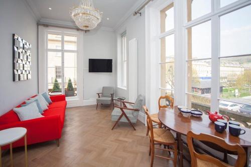 a living room with a red couch and a table at Beautiful City Centre Apartment - Bath in Bath