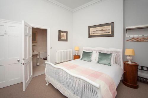 a white bedroom with a bed and a bathroom at Beautiful City Centre Apartment - Bath in Bath