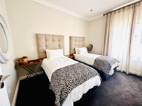 a bedroom with two beds and a window at 4 Bedroom Home, St Francis Links Golf Estate in St Francis Bay