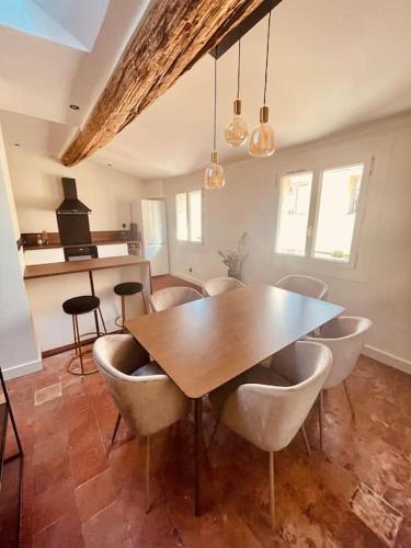 une salle à manger avec une table et des chaises en bois dans l'établissement Charmant T2bis coeur historique, Clim, possibilité garage, à Aix-en-Provence