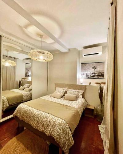 une chambre avec deux lits et un grand miroir dans l'établissement Charmant T2bis coeur historique, Clim, possibilité garage, à Aix-en-Provence