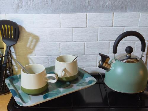 two coffee cups and a tea kettle on a counter at Shangrila-innibos Country Lodge in Hartbeespoort