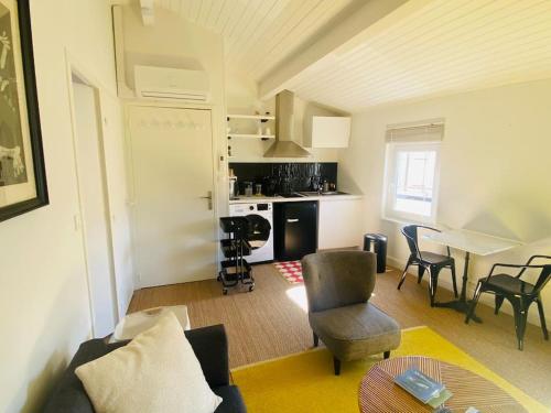 un salon avec un canapé et des chaises et une cuisine dans l'établissement Bel appartement, Oiseau 1, à Niort