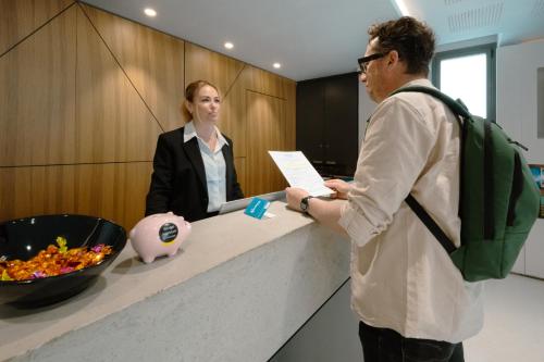 a man and a woman standing at a counter at Nemea Appart Hotel Cannes Palais in Cannes