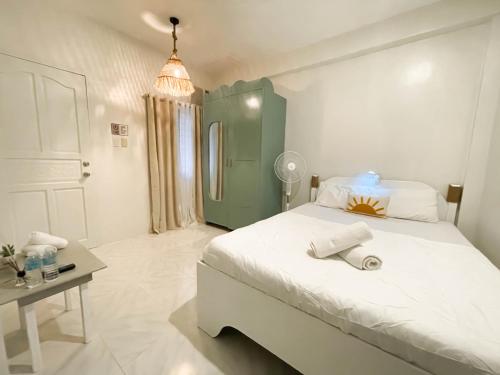 a bedroom with a large white bed and a table at Caleo Boracay Island Station 3 in Boracay