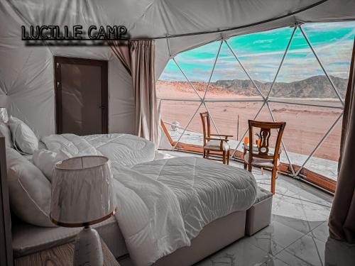 a bed in a tent with a view of the desert at Rum Lucille Luxury camp in Wadi Rum
