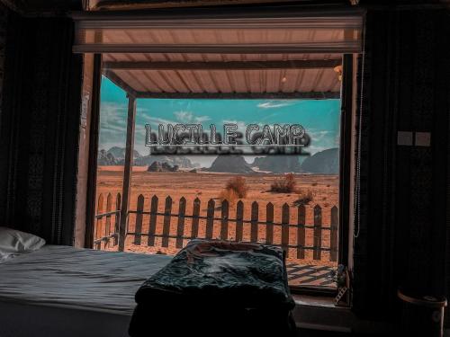 a bedroom with a window with a view of the desert at Rum Lucille Luxury camp in Wadi Rum