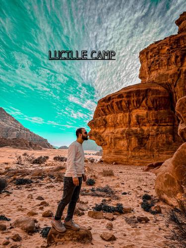 a man standing on a rock in the desert at Rum Lucille Luxury camp in Wadi Rum