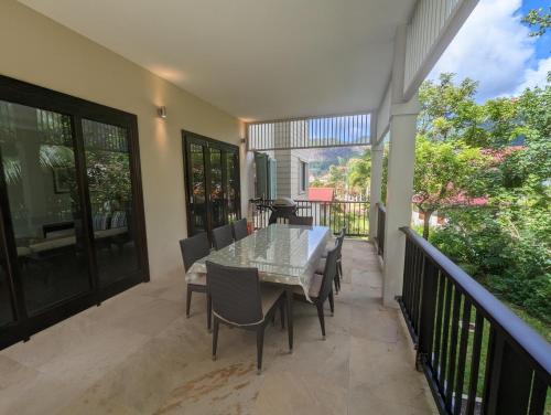 a dining room with a table and chairs on a balcony at Papay Suite by Simply-Seychelles in Eden Island