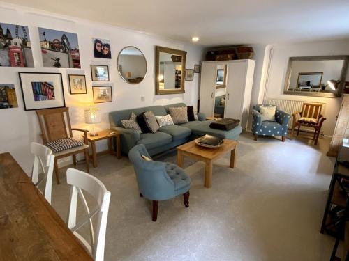 a living room with a blue couch and chairs at Spacious City Centre Apartment Bath in Bath