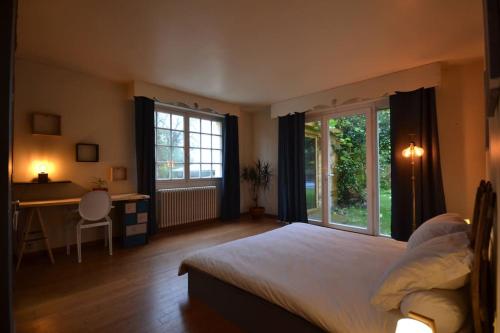 1 dormitorio con 1 cama, escritorio y ventanas en villa chanoine poupard, en Nantes