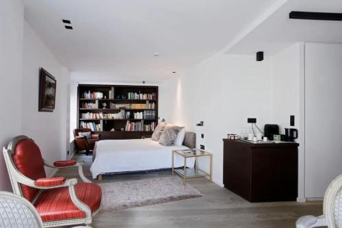 une chambre avec un lit et une étagère dans l'établissement St-Germain/Louvre - Stylish townhouse of 1600, à Paris