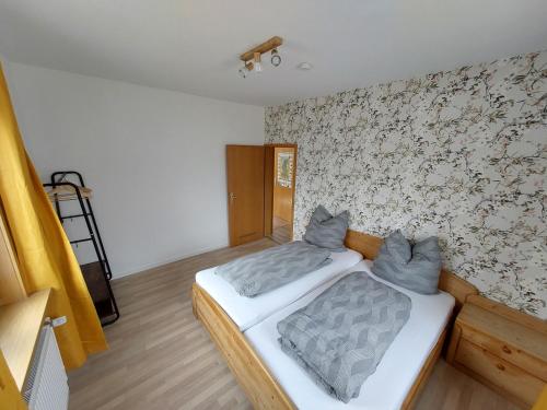 um quarto com uma cama e uma parede em FEWO SALENBERG em Freudenstadt
