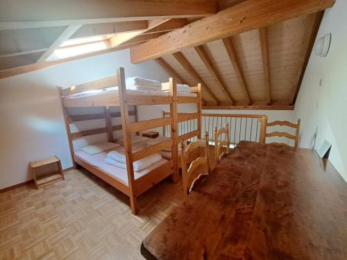 Cette chambre comprend des lits superposés et une table en bois. dans l'établissement Tariche Centre de Vacances, à Saint-Ursanne