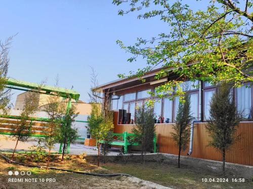 un edificio con una panchina verde davanti di СОФЬЯ ГОСТЕВОЙ ДОМ a Bukhara