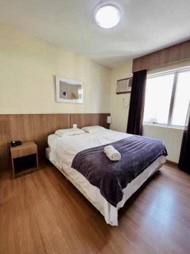 a bedroom with a large bed and a large window at LK Barro Preto 9 in Belo Horizonte